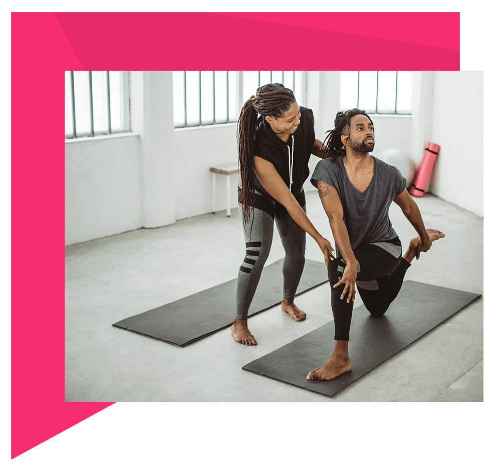 Instructor helping client in yoga pose